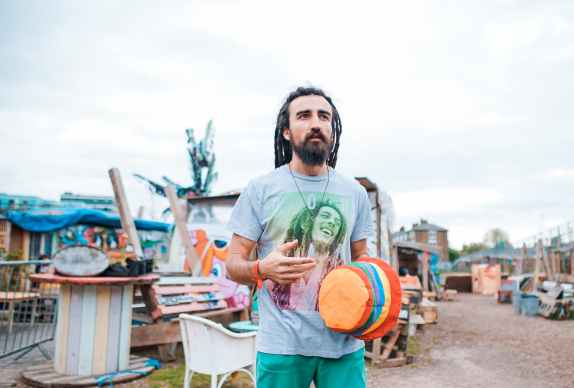 man wearing blue crew neck shirt and holding orange hat